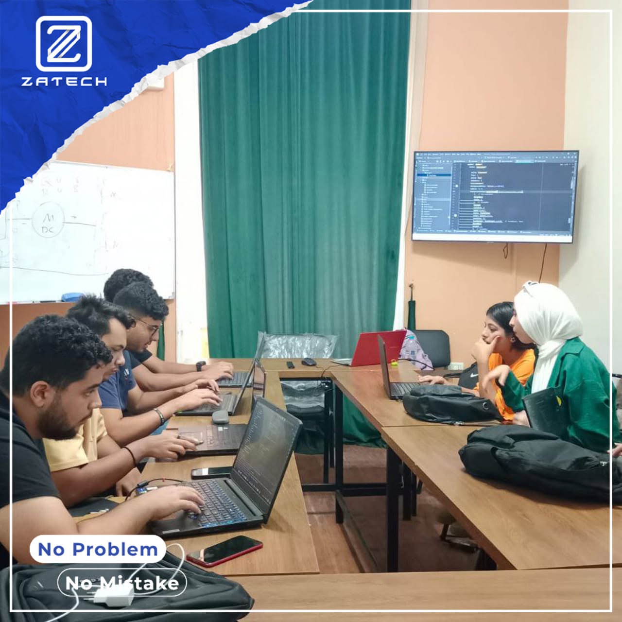متدربون يكتبون كودًا على أجهزة لابتوب في قاعة تدريب